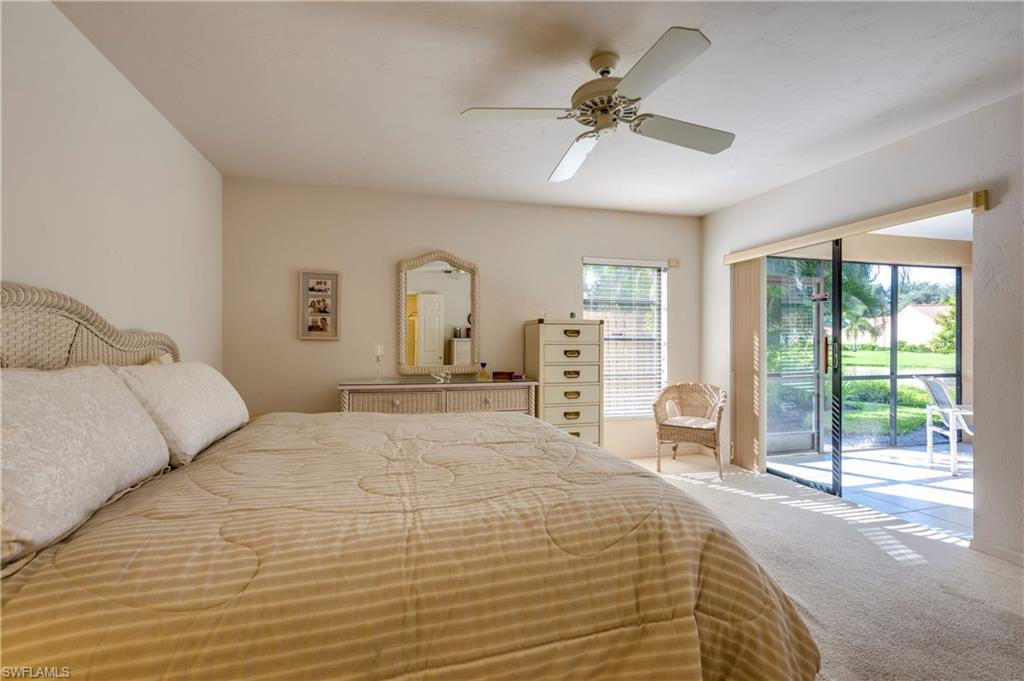 867 Reef Point Circle Naples, FL 34108 - Photo 17 of 32 Master Bedroom has a great view through sliding glass doors to lake beyond
