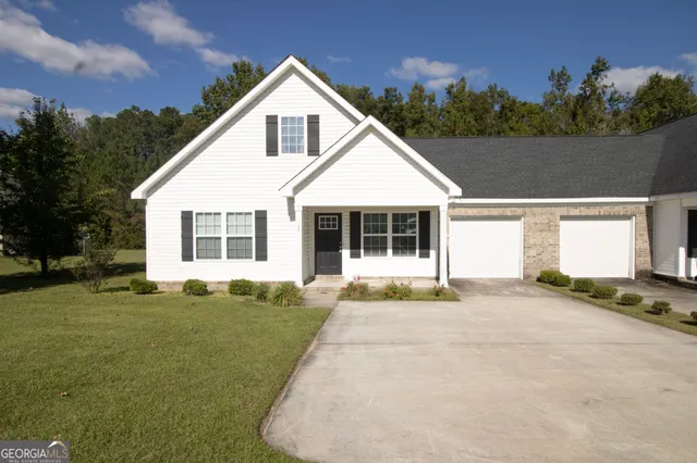 a front view of a house with a garden and yard