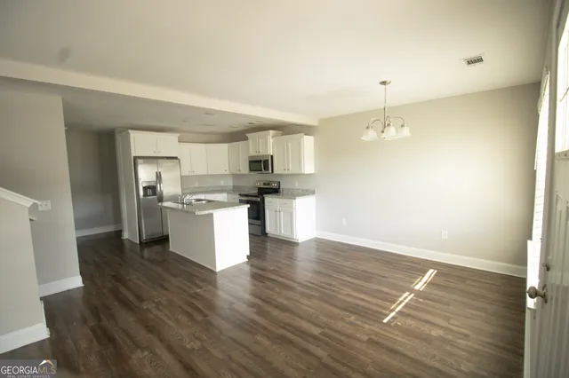 a kitchen with granite countertop wooden floors and white cabinets