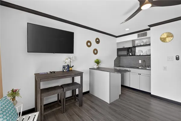 a living room with stainless steel appliances kitchen island a table and a refrigerator