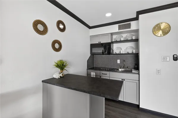 a kitchen with a sink cabinets and wooden floor