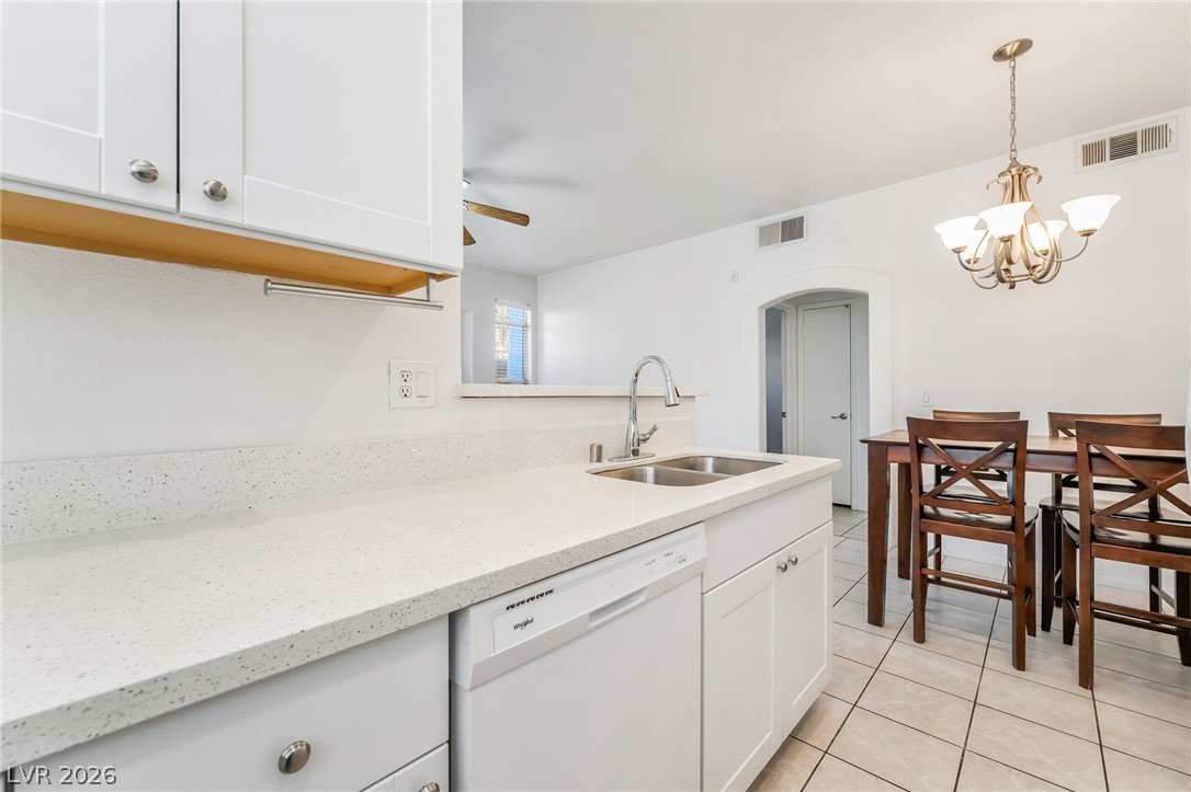 2201 Ramsgate Drive, Unit 811 Henderson, NV 89074 - Photo 13 of 36 Modern kitchen with white cabinetry and ample counter space, adjacent to a dining area.