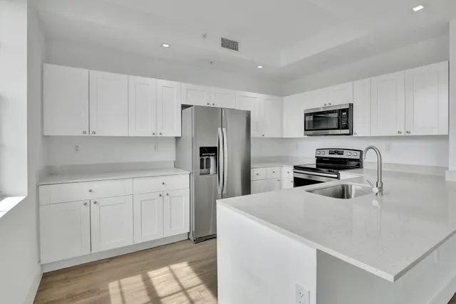 a kitchen with a refrigerator a microwave a sink and cabinets