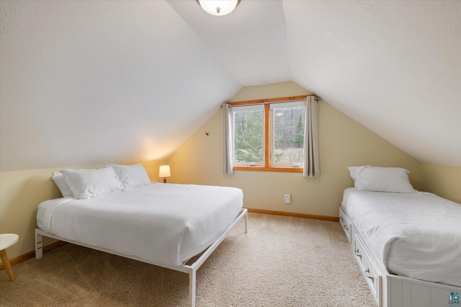 6266 Giants Ridge Road Biwabik, MN 55705 - Photo 19 of 37 Attic bedroom featuring angled ceilings, carpeted flooring, and a pair of windows with wood trim