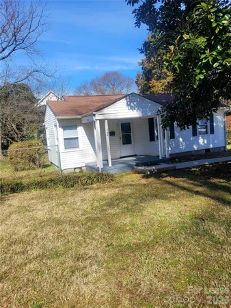 a front view of house with yard and trees around