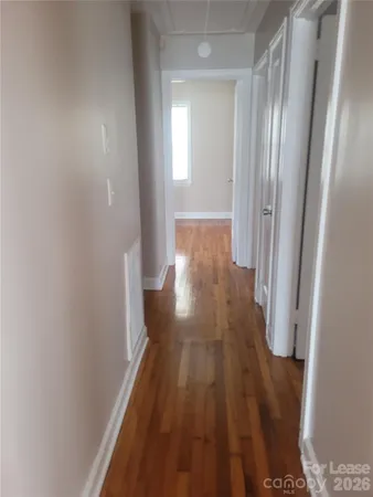 a view of a hallway with wooden floor