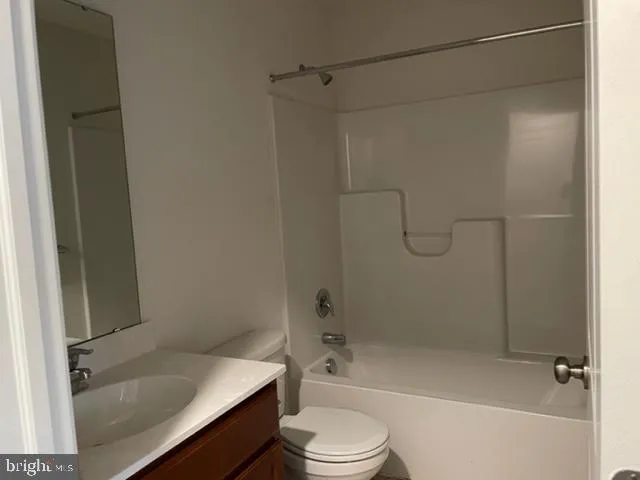 a bathroom with a granite countertop bathtub shower sink vanity and toilet