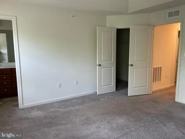 an empty room with closet and a bathroom