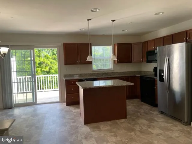 a kitchen with stainless steel appliances granite countertop a refrigerator a sink a stove and a refrigerator with wooden floor