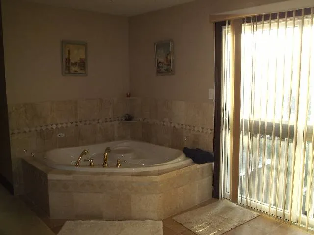 a white bath tub sitting in a bathroom next to a window