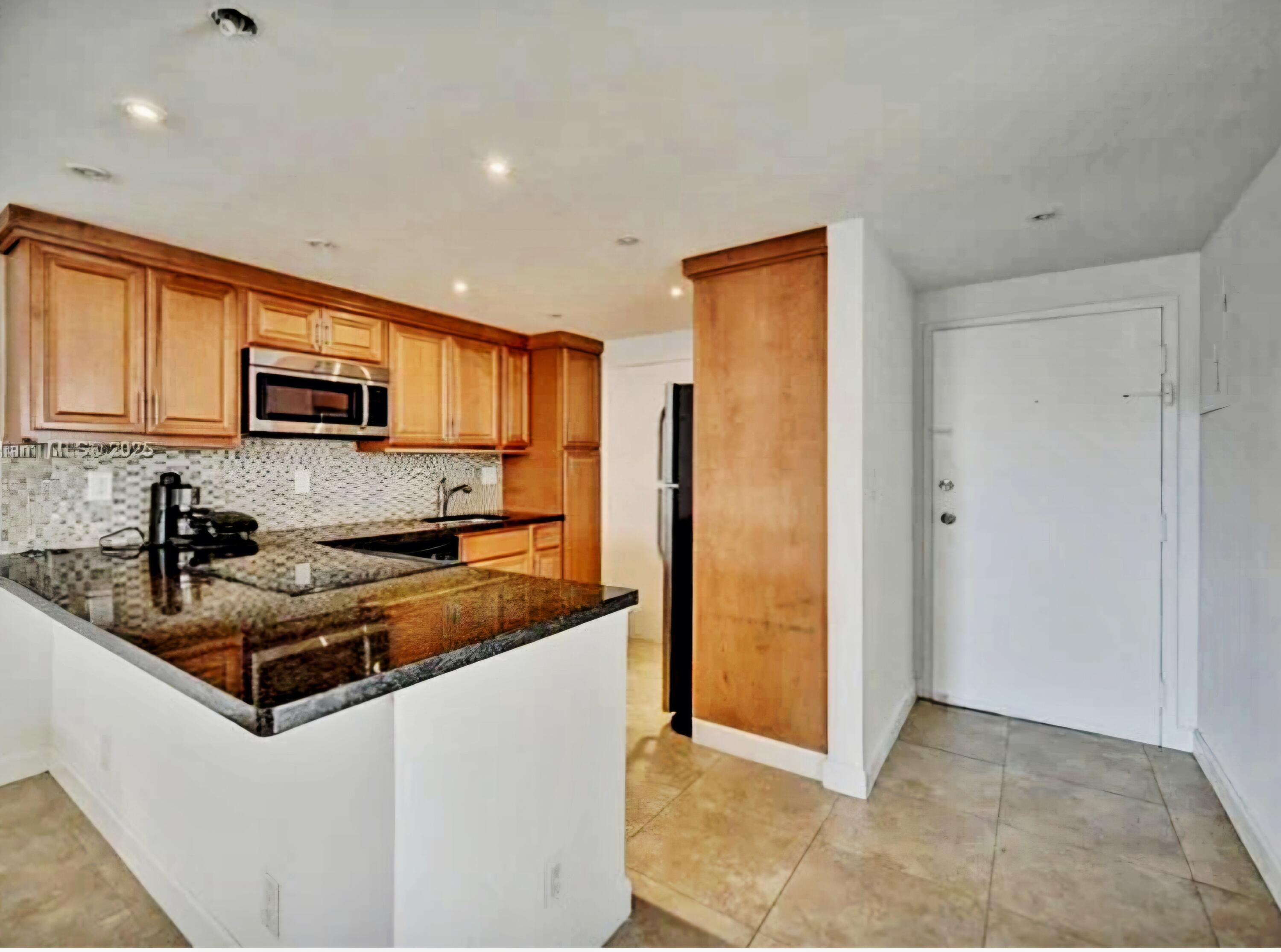 200 South Birch Road, Unit 208 Fort Lauderdale, FL 33316 - Photo 9 of 22 a kitchen with granite countertop a stove top oven a sink dishwasher and a refrigerator with wooden floor