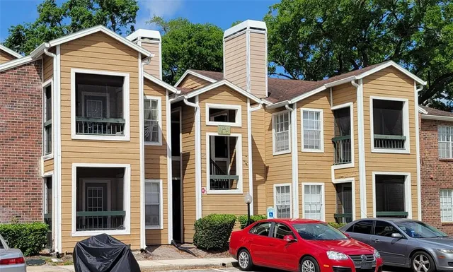 a front view of a house with cars parked