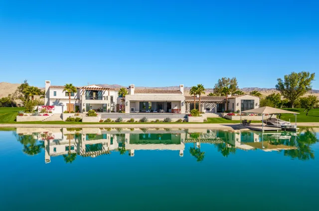a table and chairs sitting in the water in front of the house