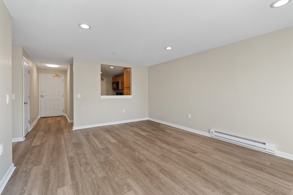2 Ocean Avenue, Unit 3H Gloucester, MA 01930 - Photo 5 of 28 a view of an empty room with wooden floor and a window