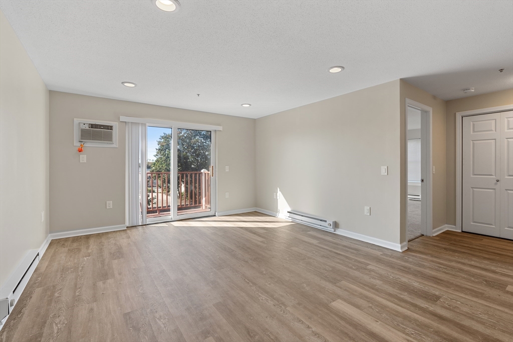 2 Ocean Avenue, Unit 3H Gloucester, MA 01930 - Photo 6 of 28 a view of an empty room with wooden floor and a window