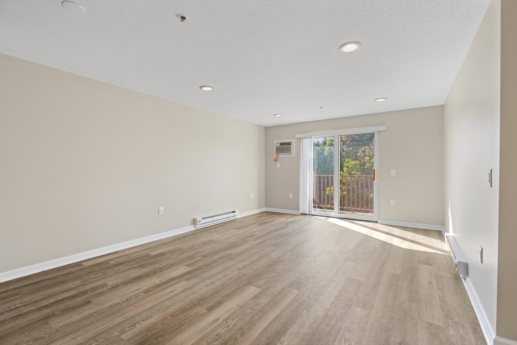2 Ocean Avenue, Unit 3H Gloucester, MA 01930 - Photo 7 of 28 a view of an empty room with wooden floor and a window