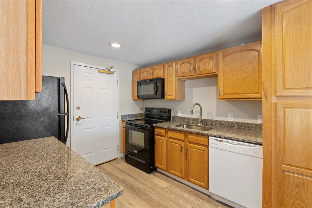 2 Ocean Avenue, Unit 3H Gloucester, MA 01930 - Photo 9 of 28 a kitchen with stainless steel appliances granite countertop a refrigerator sink and stove