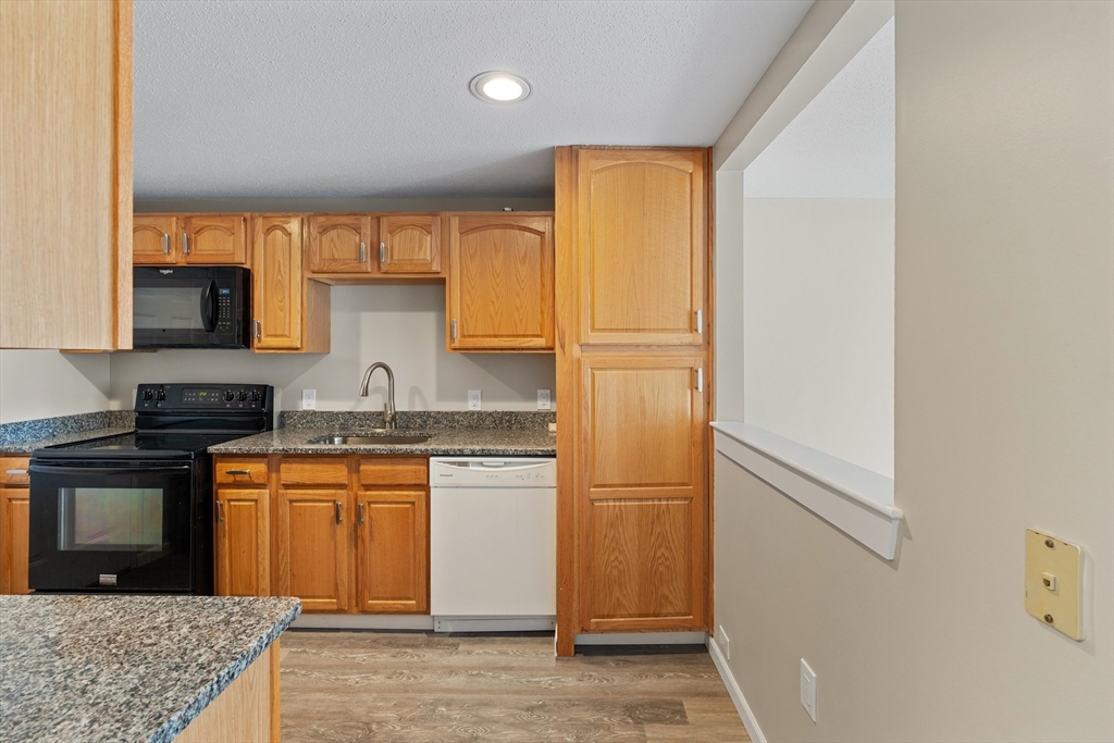 2 Ocean Avenue, Unit 3H Gloucester, MA 01930 - Photo 10 of 28 a kitchen with stainless steel appliances granite countertop a refrigerator a stove and a sink with wooden floor