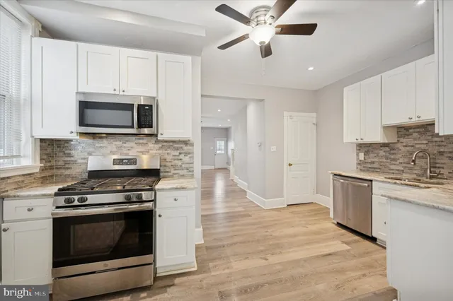 a kitchen with granite countertop a stove top oven microwave and cabinets