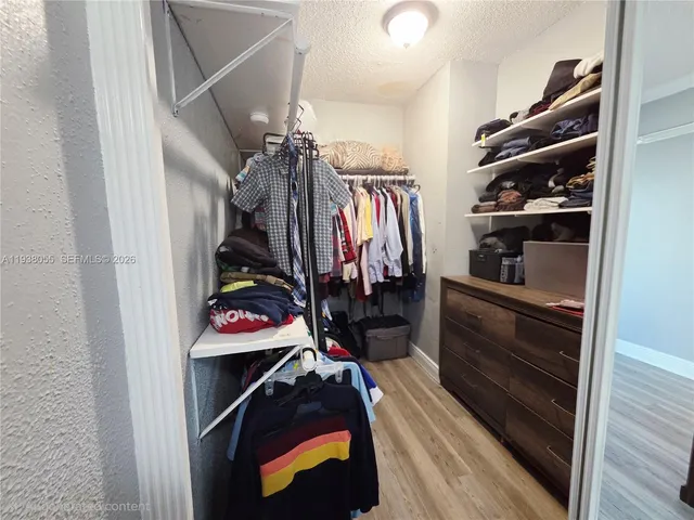 a view of walk in closet with clothes and shoes