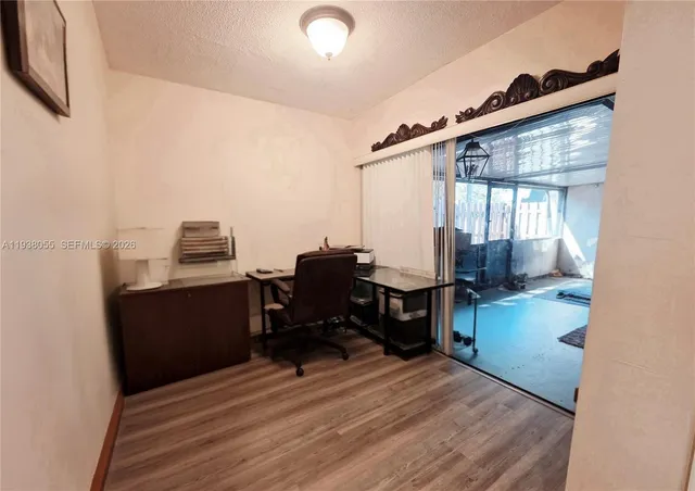 a view of a workspace with furniture and a window