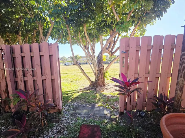 a view of a backyard with wooden fence