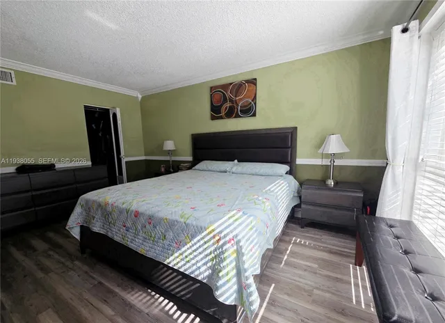 a bedroom with bed and wooden floor