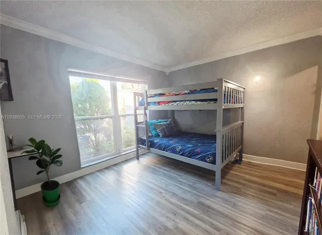 a bedroom with wooden floor and a window
