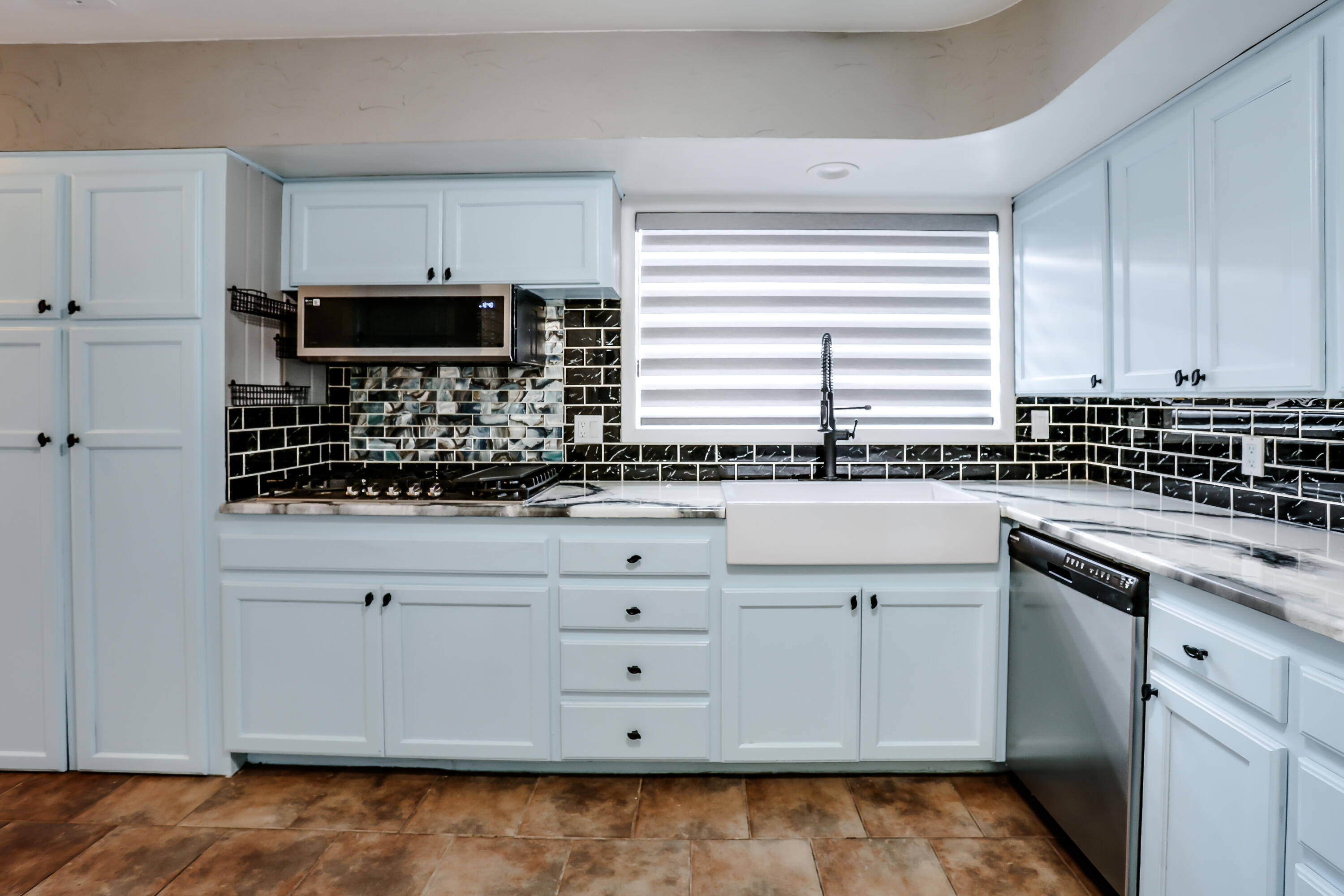3615 47th Street Lubbock, TX 79413 - Photo 5 of 36 a kitchen with white cabinets and appliances
