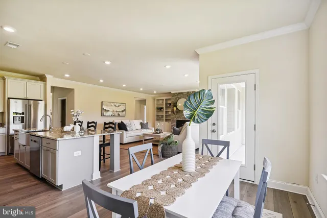 a living room with stainless steel appliances kitchen island granite countertop furniture and wooden floor