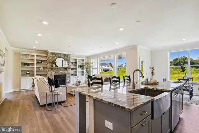 a kitchen with stainless steel appliances granite countertop a sink and wooden floors
