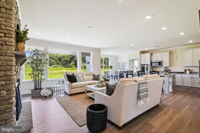 a living room with furniture wooden floor and a large window