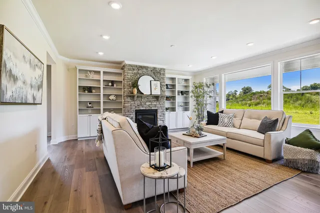 a living room with fireplace furniture and a large window