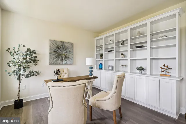 a white room with a potted plant and a wooden floor