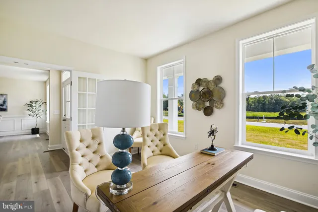 a view of a workspace with furniture and floor to ceiling window