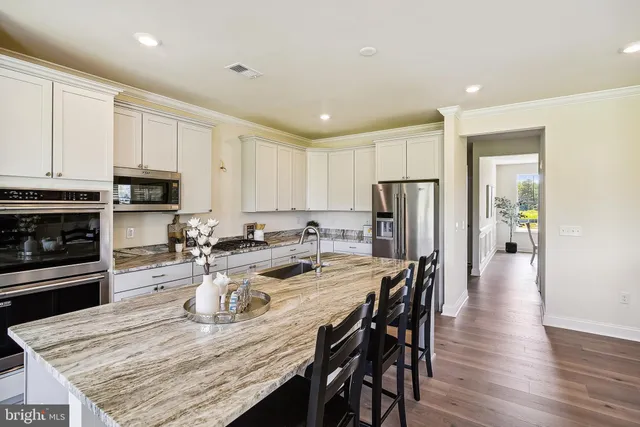 a view of kitchen with cabinets stainless steel appliances and dining table