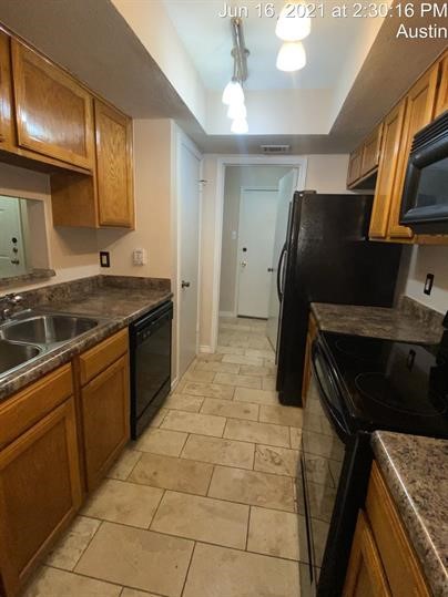 512 Eberhart Lane, Unit 103 Austin, TX 78745 - Photo 5 of 18 a kitchen with a refrigerator and a sink