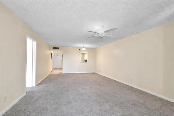 an empty room with a ceiling fan and a window