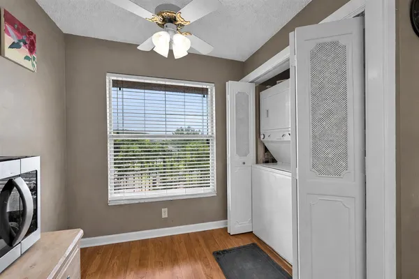 a view of an empty room with a window and wooden floor