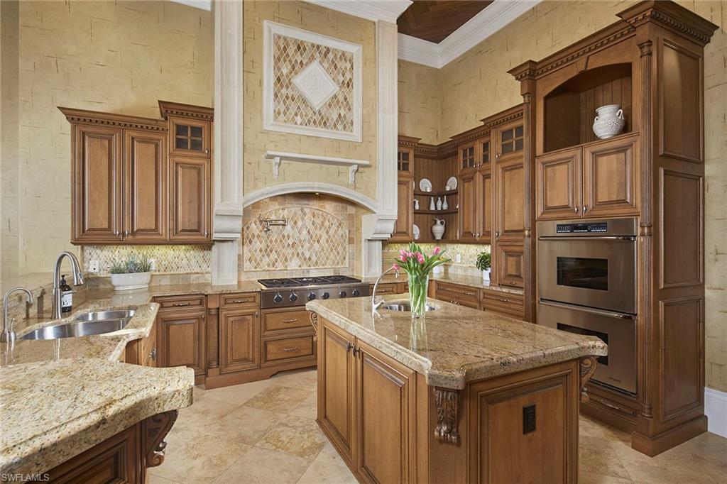 2944 Bellflower Lane Naples, FL 34105 - Photo 11 of 48 a kitchen with stainless steel appliances granite countertop a sink stove and refrigerator