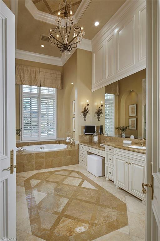 2944 Bellflower Lane Naples, FL 34105 - Photo 19 of 48 a spacious bathroom with a sink a large mirror and a bathtub