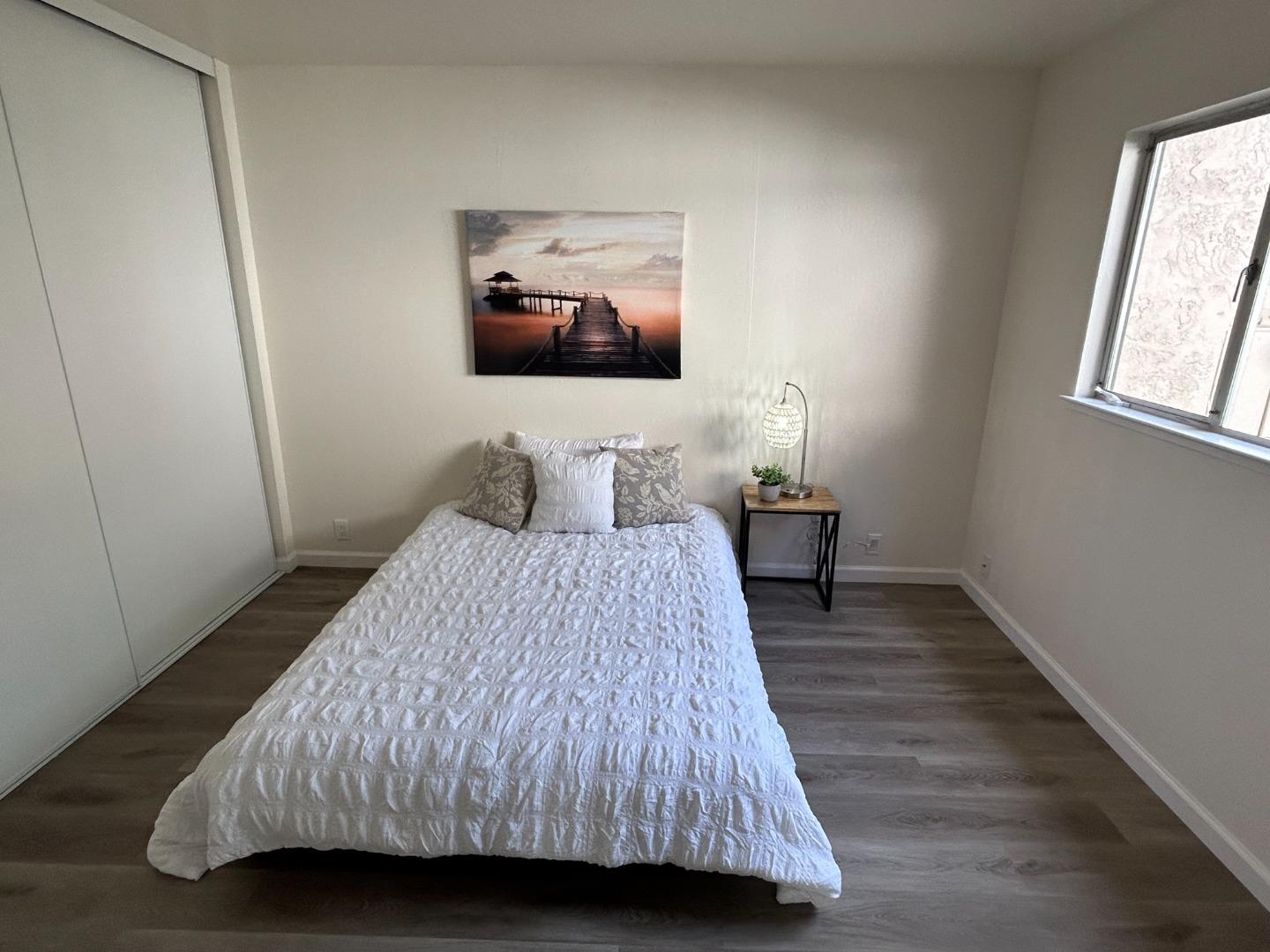 1242 Terra Nova Boulevard Pacifica, CA 94044 - Photo 6 of 26 a bedroom with a bed and wooden floor