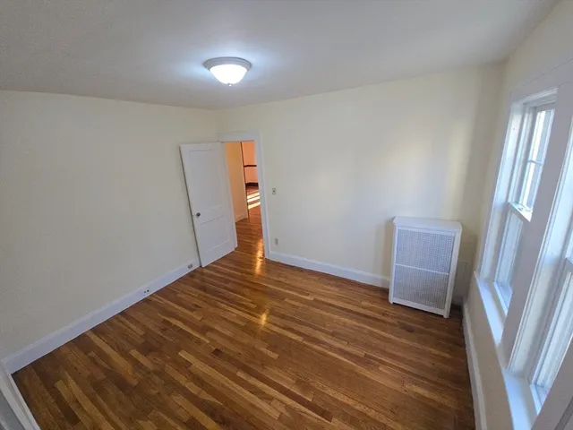 a view of room with wooden floor and stairs