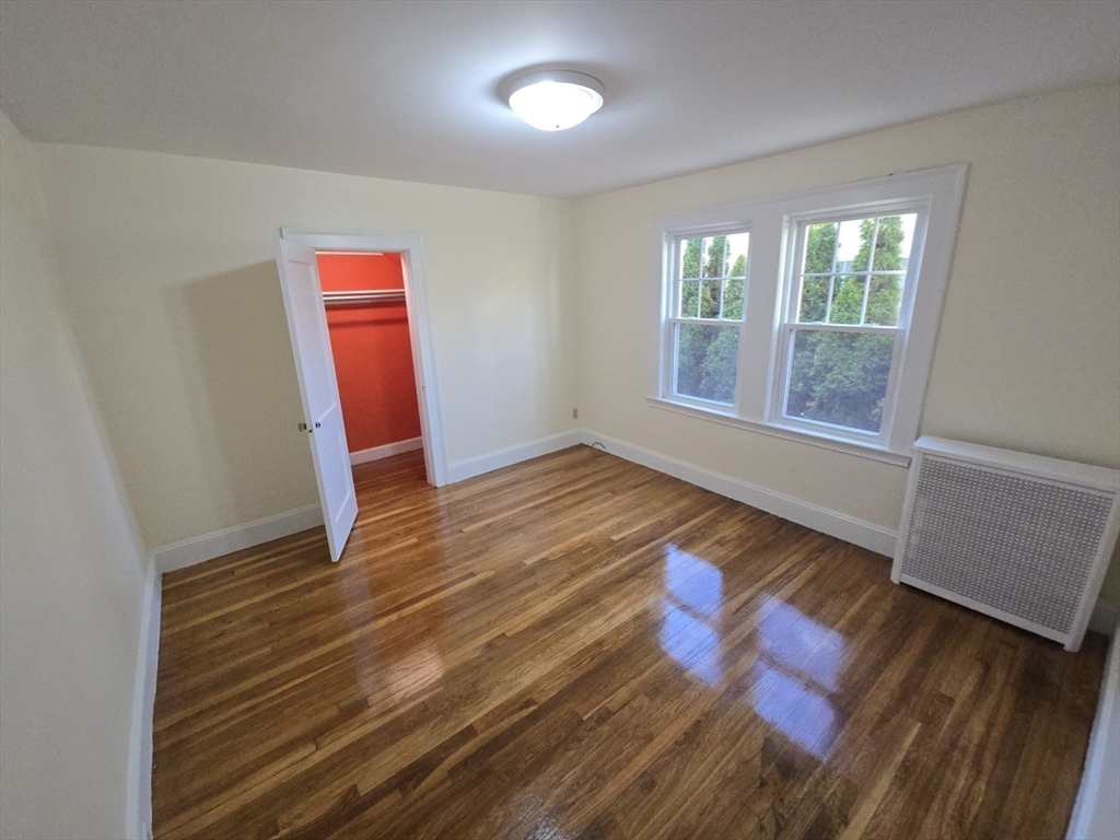 58 Creeley Road, Unit 1 Belmont, MA 02478 - Photo 12 of 15 a view of an empty room with wooden floor and a window