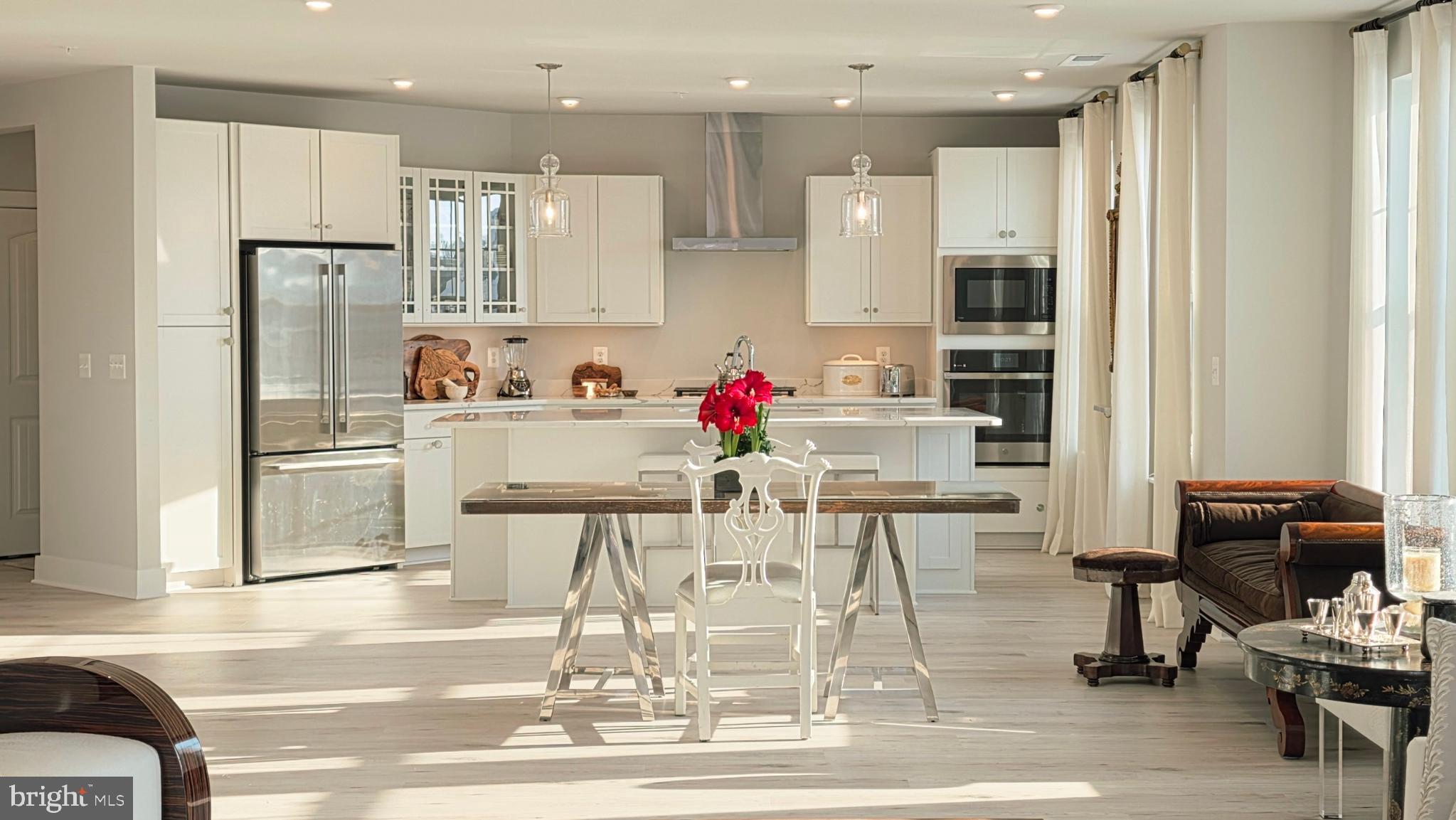 230 Switchgrass Way, Unit 21 Chester, MD 21619 - Photo 2 of 66 a kitchen with stainless steel appliances kitchen island granite countertop a dining table chairs and white cabinets