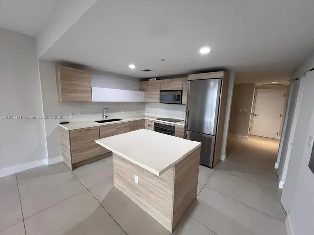 a view of kitchen with stainless steel appliances a refrigerator and a stove top oven