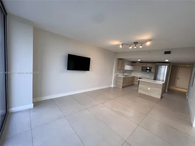 an empty room with sliding glass door and mountain view
