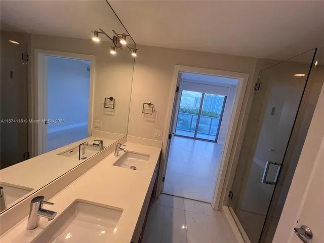 a bathroom with a double vanity sink mirror and shower