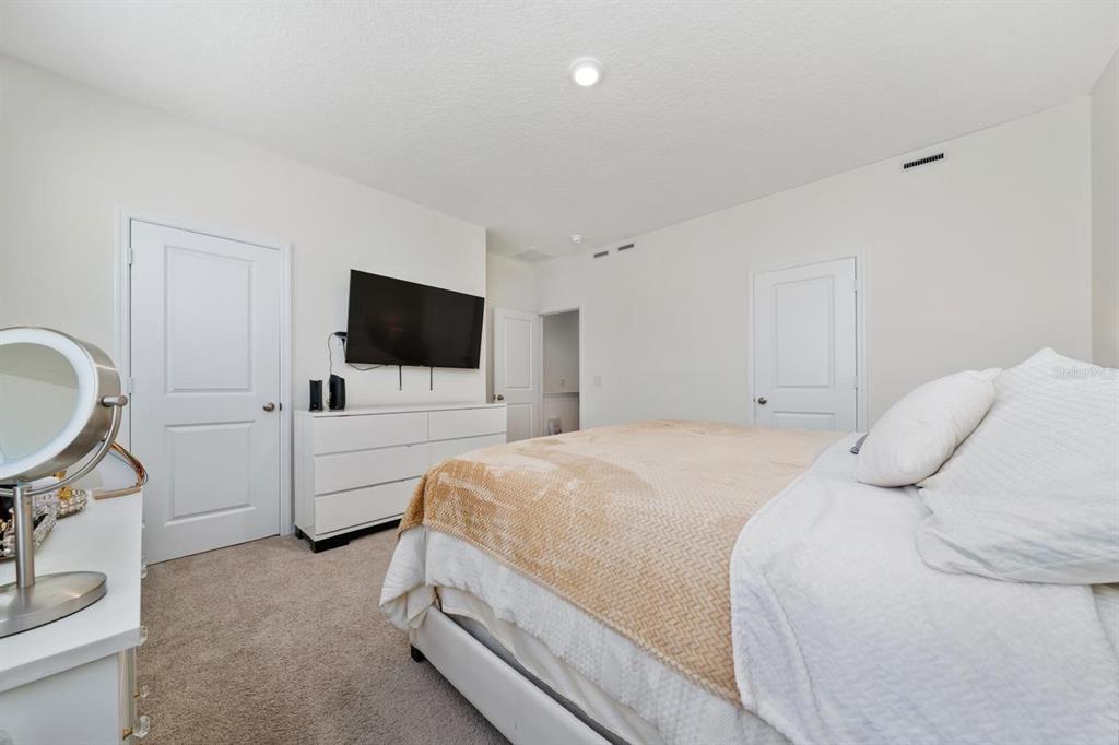 4450 Small Creek Road Kissimmee, FL 34744 - Photo 14 of 25 a bedroom with a bed and a flat screen tv