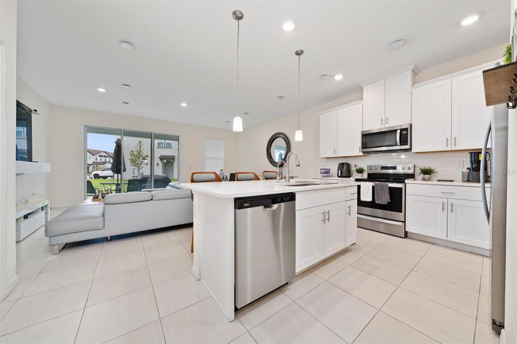 4450 Small Creek Road Kissimmee, FL 34744 - Photo 7 of 25 a kitchen with stainless steel appliances granite countertop a refrigerator sink and white cabinets
